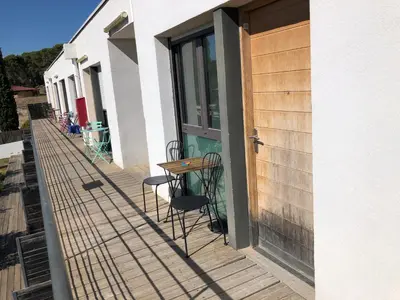 a wooden deck with a table and chairs on it at Ma place au sud 1 in Éguilles