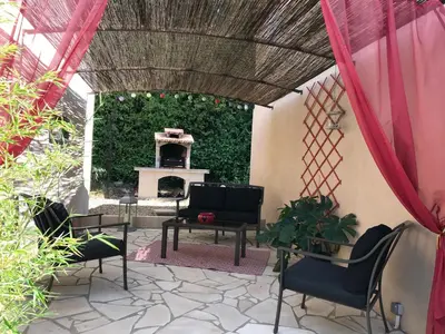 a patio with a living room with a fireplace at Les Hauts d'Eyragues gîte Aigue Marine Meublé classé 4 étoiles in Eyragues