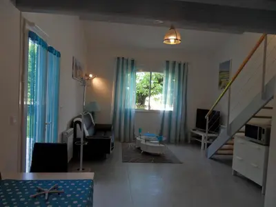 a living room with blue curtains and a staircase at Les Hauts d'Eyragues gîte Aigue Marine Meublé classé 4 étoiles in Eyragues