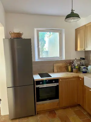 a kitchen with a stainless steel refrigerator and a window at Charming village house in Goult in Goult