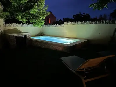 a swimming pool in a backyard at night at Charming village house in Goult in Goult