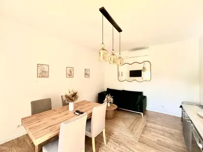 a kitchen and dining room with a wooden table and chairs at Appartement eygalieres avec petit jardin in Eygalières