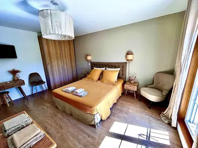 a bedroom with a bed and a couch and a chair at Le Mas Justin in Gordes