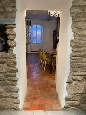 a dining room with a table and yellow chairs at La Maison Rose in Caromb