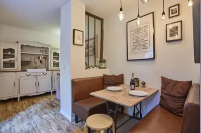 a dining room with a table and a couch at Appart Aix sauna jacuzzi balneo spa privatifs hyper centre historique cour intérieur in Aix-en-Provence