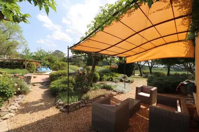 a garden with a large yellow umbrella and chairs at Villa avec Piscine et Vues Imprenables in Villars