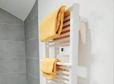 a bathroom with a white towel rack with towels at Joli studio au calme, centre historique de Pertuis in Pertuis