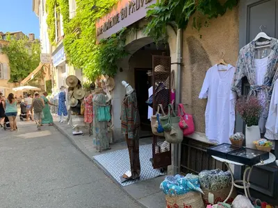 a street with a store with clothes on display at Cocon du Papillon à Lourmarin in Lourmarin