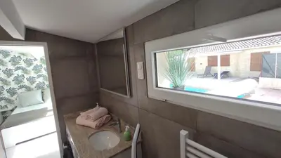 a small bathroom with a sink and a window at La maison de Marie Hélène 2 piscine partagée in Aix-en-Provence