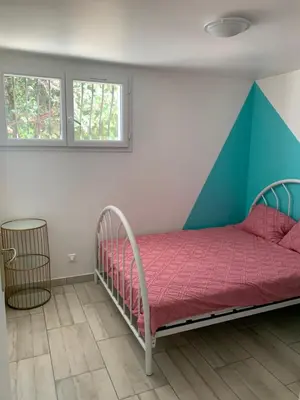 a bedroom with a bed with a geometric headboard at Charmant logement avec un extérieur et un jacuzzi in Lançon-Provence
