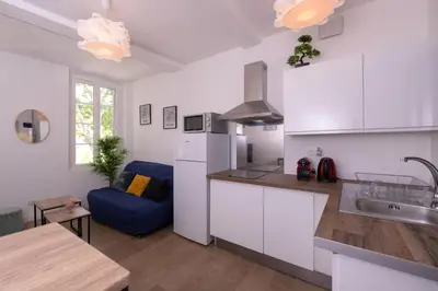 a kitchen with white cabinets and a blue couch at Le Nostradamus - Magnifique appartement cours principal plein centre avec parking in Salon-de-Provence