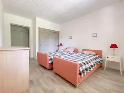 a bedroom with a bed and two orange chairs at Gites Partage des Eaux L'isle sur la Sorgue in LʼIsle-sur-la-Sorgue