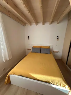a bedroom with a large bed with a yellow bedspread at Paisible gîte moderne avec vue sur le Luberon in La Motte-dʼAigues