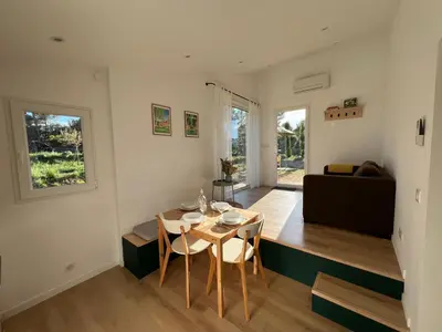 a living room with a table and a couch at Paisible gîte moderne avec vue sur le Luberon in La Motte-dʼAigues