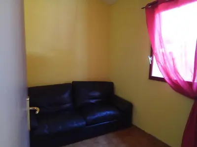 a black leather couch in a room with a window at Mes deux Gîtes de l'Ocre in Villars