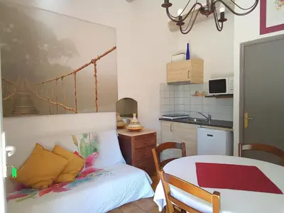 a small room with a bed and a kitchen at Mes deux Gîtes de l'Ocre in Villars