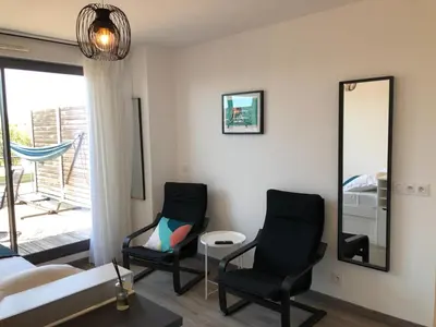 a living room with two chairs and a mirror at Ma place au sud terrasse à 2 pas d’Aix in Éguilles