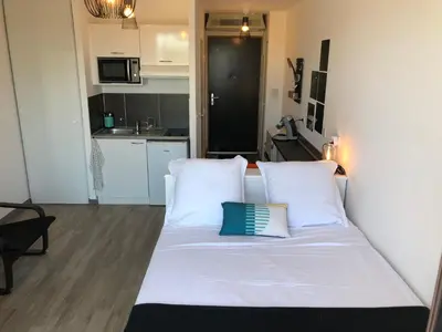 a white bed with two pillows in a room at Ma place au sud terrasse à 2 pas d’Aix in Éguilles