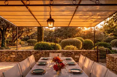 a table with plates and wine glasses on it at Ravissante Bastide Provencale 5 etoiles - Cadre idyllique - Piscine chauffée in Bonnieux