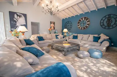 a living room with a large clock on the wall at Ravissante Bastide Provencale 5 etoiles - Cadre idyllique - Piscine chauffée in Bonnieux