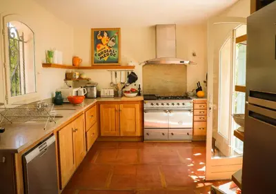 a kitchen with wooden cabinets and a stove at La Villa La Source à Aix en Provence in Aix-en-Provence