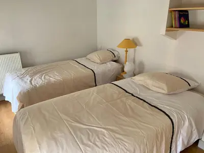 two beds in a room with white walls at Au cœur de l’Isle sur sorgue in LʼIsle-sur-la-Sorgue