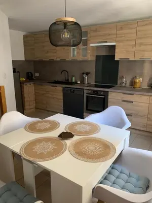 a kitchen with a white table with white chairs at Au cœur de l’Isle sur sorgue in LʼIsle-sur-la-Sorgue