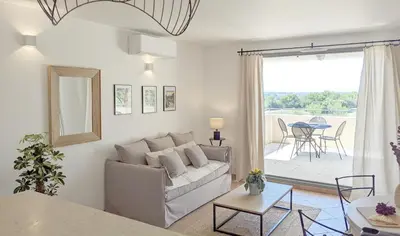 a kitchen with white cabinets and a counter with wine glasses at ALLURA GOLF APPARTEMENT in Saumane-de-Vaucluse