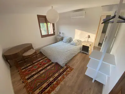 a bedroom with a bed and a table and a mirror at Maison, Centre-ville, 6 lits, terrasse & parking in Apt