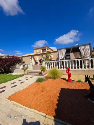 a house with a red fire hydrant in a yard at L'endroit incontournable in Les Baïsses