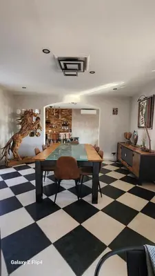 a dining room with a table and a checkered floor at L'endroit incontournable in Les Baïsses