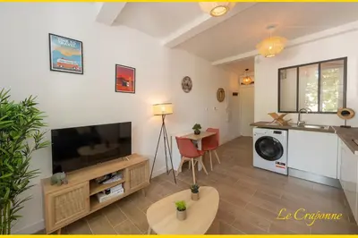 a living room with a television and a kitchen at Le Craponne - Magnifique appartement cours principal plein centre avec parking in Salon-de-Provence