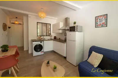 a living room with a blue couch and a kitchen at Le Craponne - Magnifique appartement cours principal plein centre avec parking in Salon-de-Provence