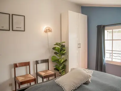 a bedroom with a bed and two chairs at Villa Cantirane in Saint-Pierre-de-Vassols