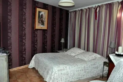 a bedroom with a bed and a picture on the wall at Chambres d'Hôtes dans villa avec piscine chez Raphaële in LʼIsle-sur-la-Sorgue