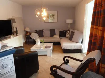 a living room with a couch and a table at Chambres d'Hôtes dans villa avec piscine chez Raphaële in LʼIsle-sur-la-Sorgue