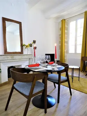 a dining room with a table with a candle and chairs at BLUE FOUNTAIN Luxueux Studio Aix Centre Historique -WIFI-SMART TV- in Aix-en-Provence