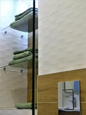 a stack of green towels in a room with a mirror at BLUE FOUNTAIN Luxueux Studio Aix Centre Historique -WIFI-SMART TV- in Aix-en-Provence