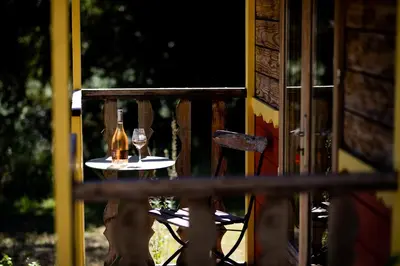 a table with a bottle and two glasses on it at Domaine Les Perpetus in La Tour-dʼAigues