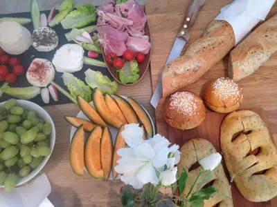 a wooden table topped with different types of bread and vegetables at Mas Notre Dame in Eygalières