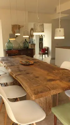 a dining room with a wooden table and white chairs at Mas Notre Dame in Eygalières