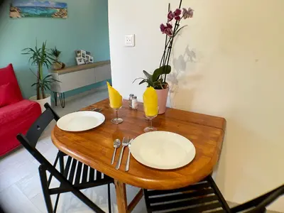 a wooden table with two plates and glasses on it at Anse Coco Luberon - Au calme, gite en Provence avec piscine partagée et parking in Pertuis