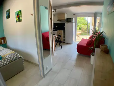 a living room with a red couch and a mirror at Anse Coco Luberon - Au calme, gite en Provence avec piscine partagée et parking in Pertuis