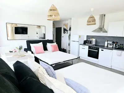 a living room with a couch and a kitchen at Lakeside Provence - Appartement classé 4 étoiles, Vue sur le lac de Monteux, Parking sous-sol, double clim in Monteux