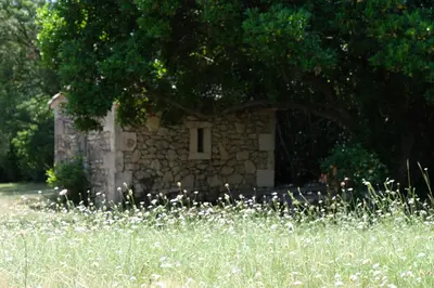 a stone building with a window in a field of grass at very pleasant provençal mas, typical to the region, with heated pool in saint remy de provence - 9 people in Saint-Rémy-de-Provence