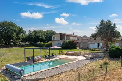 a swimming pool in a yard with a house at Domaine Mas Côté Cour in Maubec