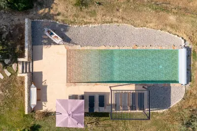 an overhead view of a swimming pool with a pink umbrella at Domaine Mas Côté Cour in Maubec