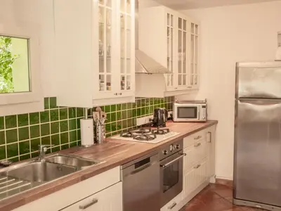 a kitchen with white cabinets and a stainless steel refrigerator at Villa Martinet in Carpentras