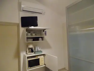 a room with a microwave and a tv on the wall at Chambre indépendante in Apt
