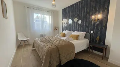 a bedroom with a large bed with a blue wall at Maison Le Clos Du Moulin 2 - Climatisée, jardin & parking gratuit - 3 chambres doubles - 10 min Avignon in Entraigues-sur-la-Sorgue